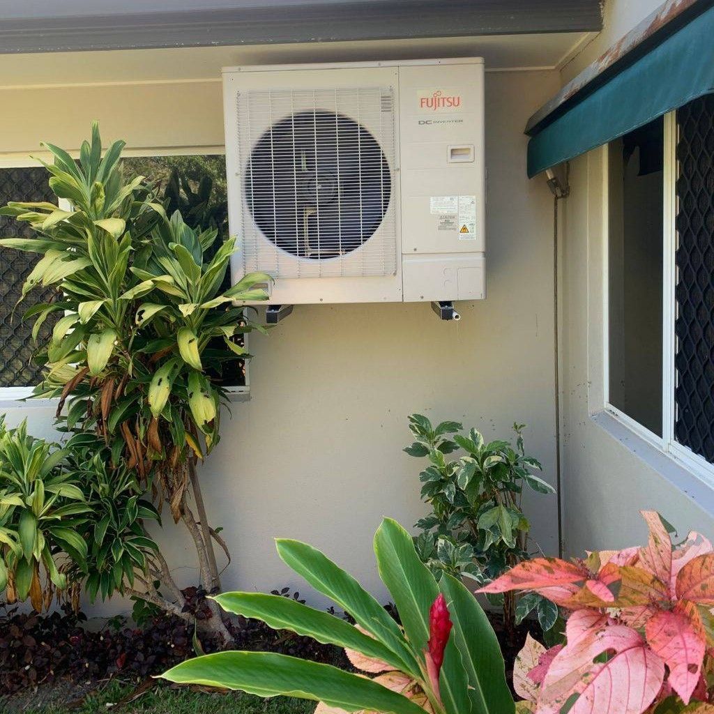 Outdoor Air Conditioner on a Wall, Surrounded — Don Hall Air Conditioning & Electrical in Smithfield, QLD