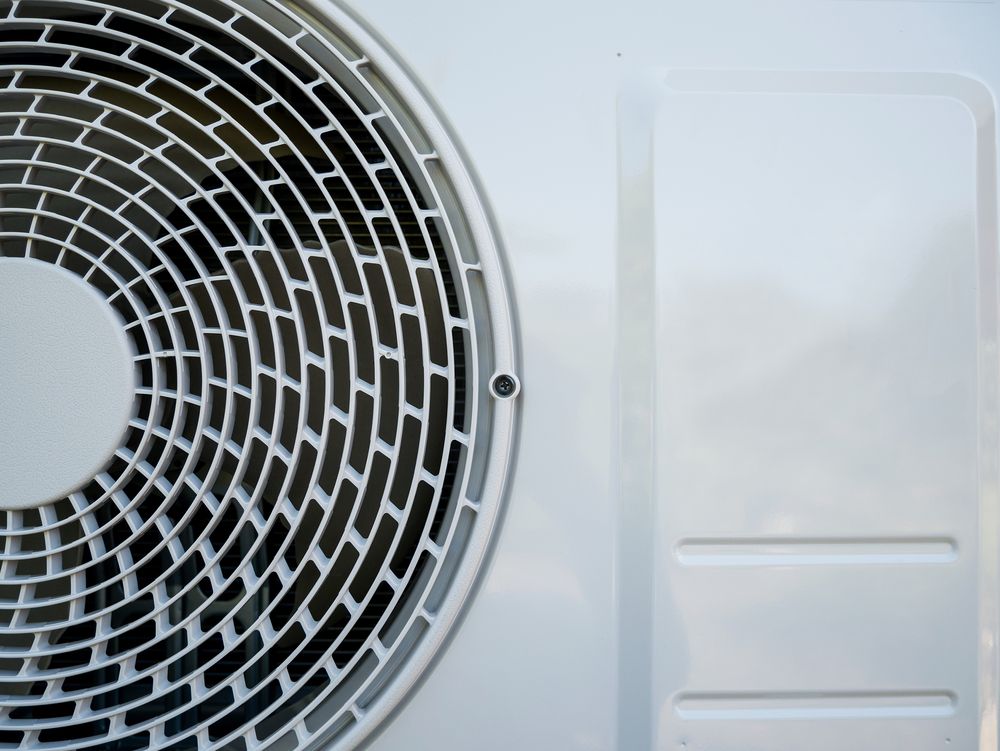 Close-up of a White Air Conditioner Unit's Fan — Don Hall Air Conditioning & Electrical in Smithfield, QLD