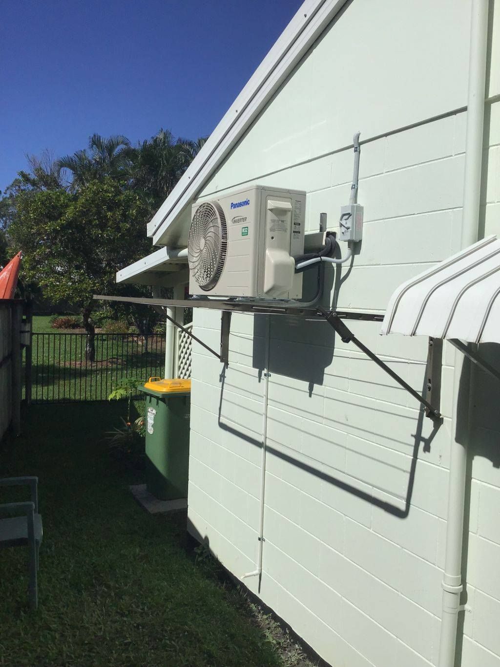 Air Conditioner Mounted on a Light Green House Exterior — Don Hall Air Conditioning & Electrical in Mareeba, QLD