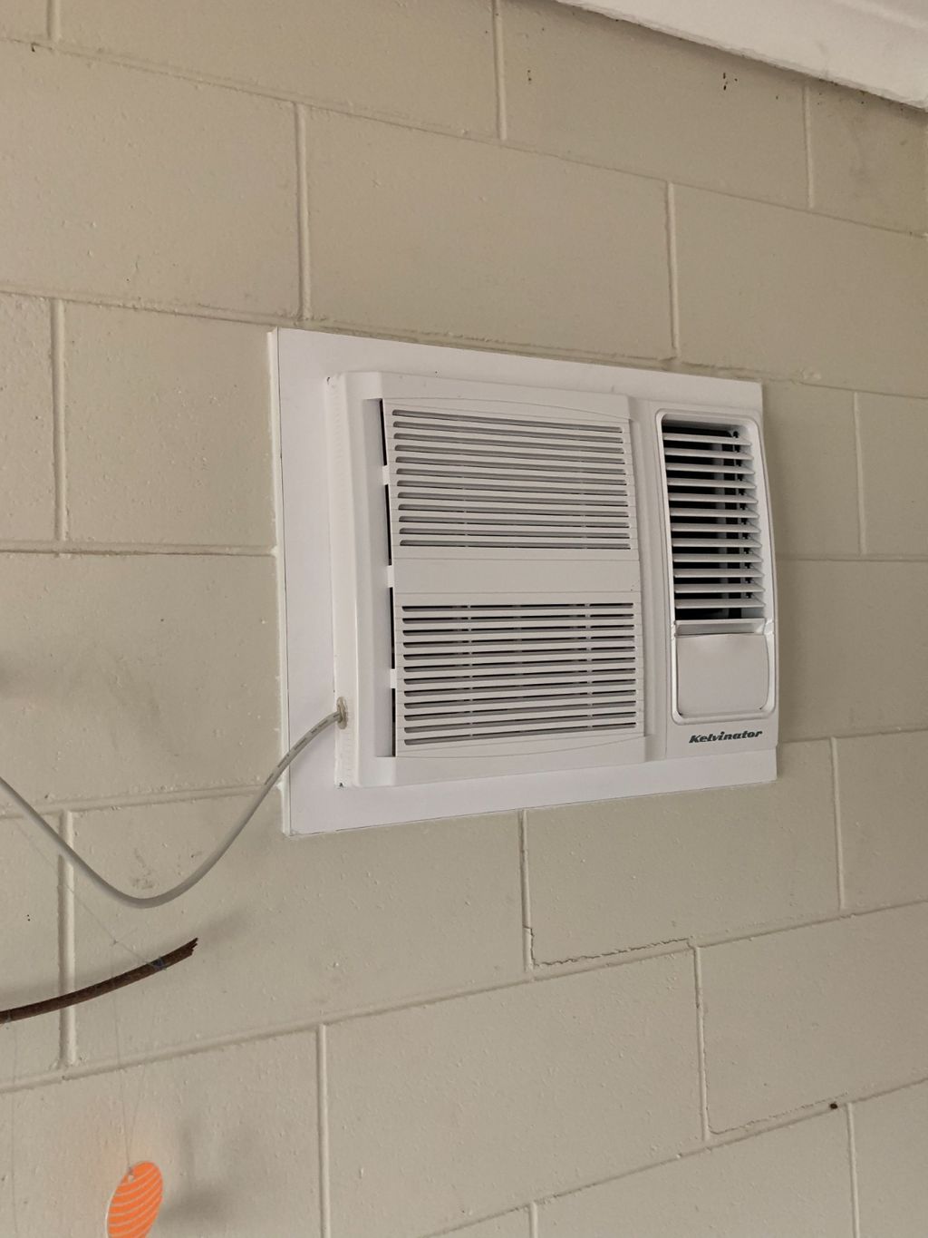 White Air Conditioner in a Cinder Block Wall — Don Hall Air Conditioning & Electrical in Smithfield, QLD
