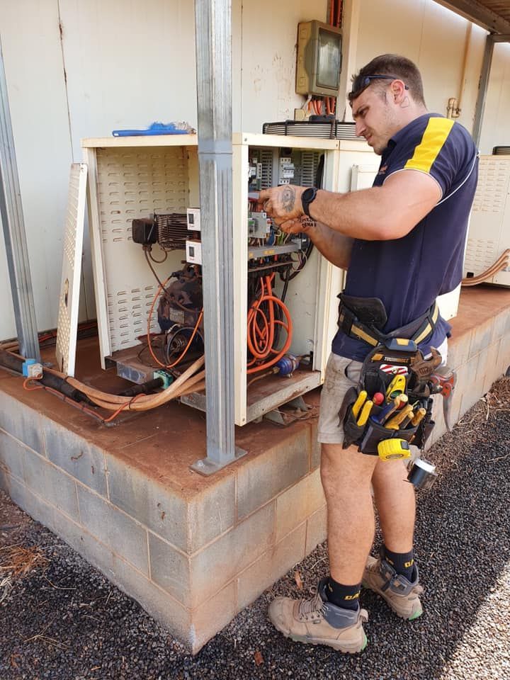 Electrician in Shorts Repairs Machinery — Don Hall Air Conditioning & Electrical in Smithfield, QLD