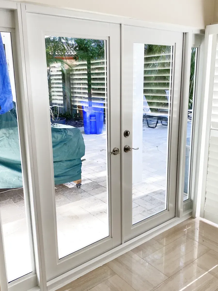 White French doors with glass panels looking out onto a tiled patio area.