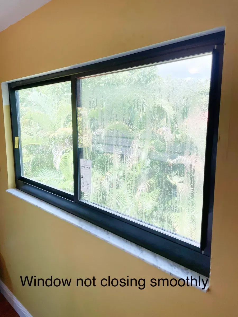 A black-framed horizontal sliding window on a yellow wall, labeled 