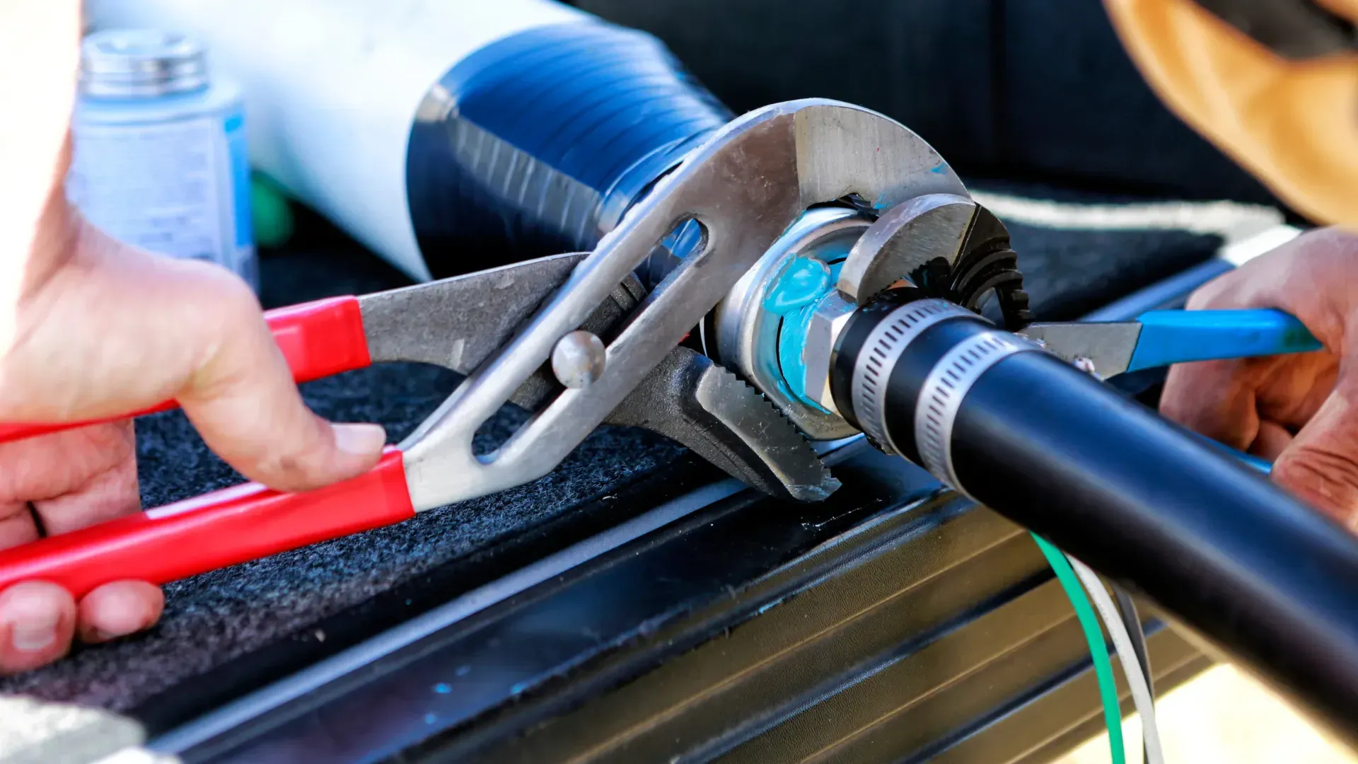 A person is working on a pipe with a wrench.