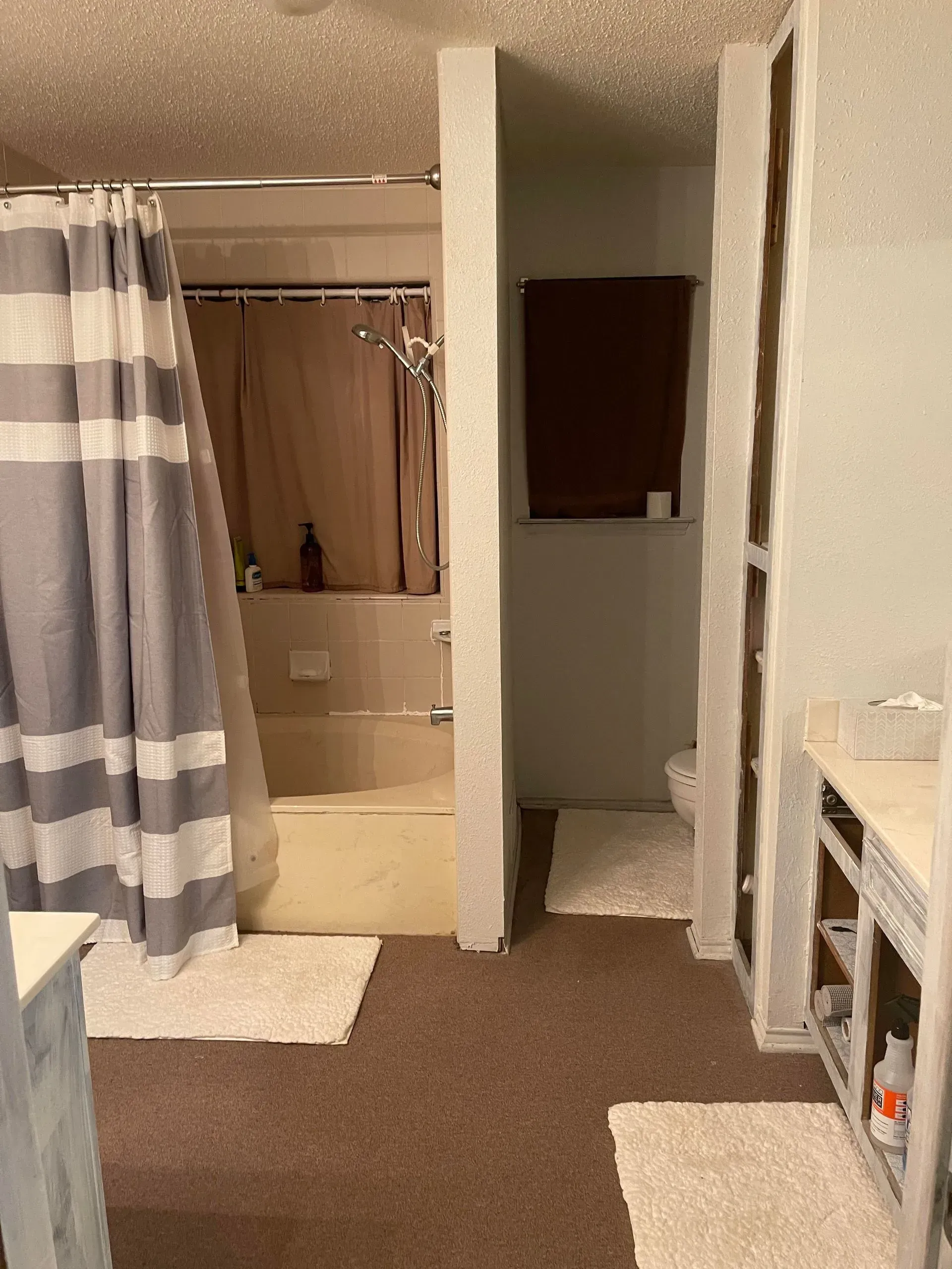 A bathroom with a striped shower curtain and a bathtub.