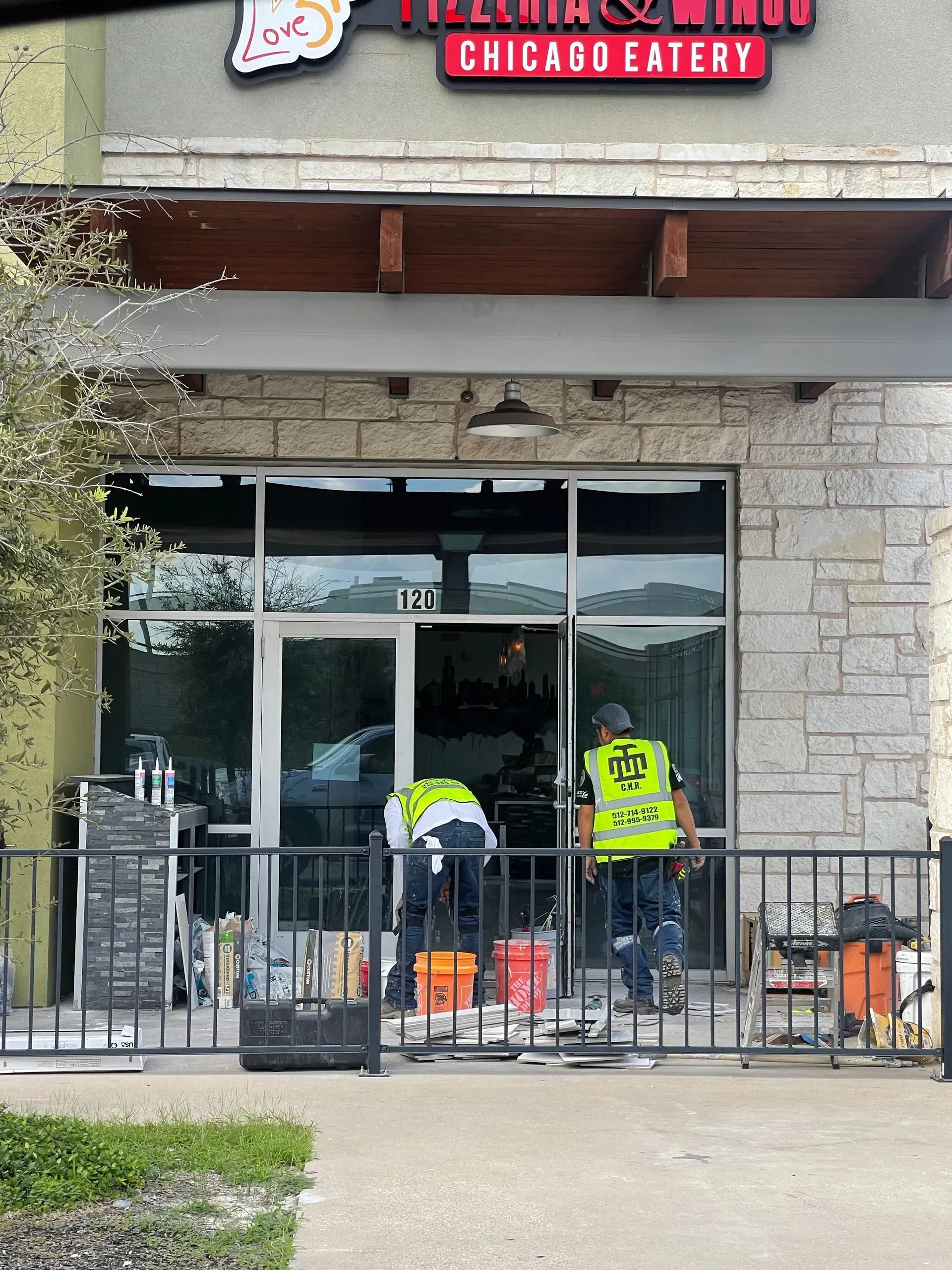 A man in a yellow vest is standing in front of a chicago eatery