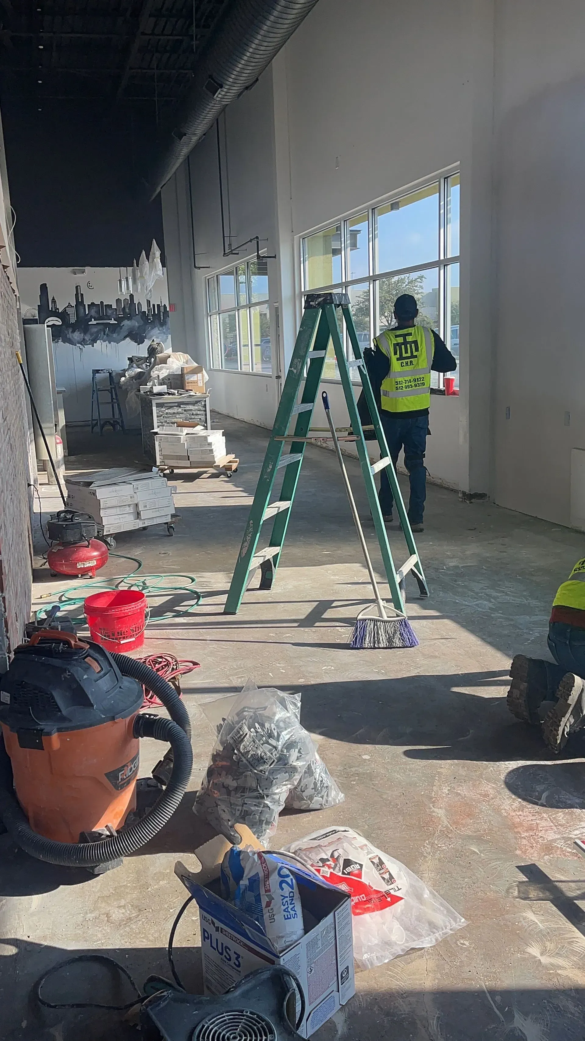 A man is standing next to a ladder in a room.