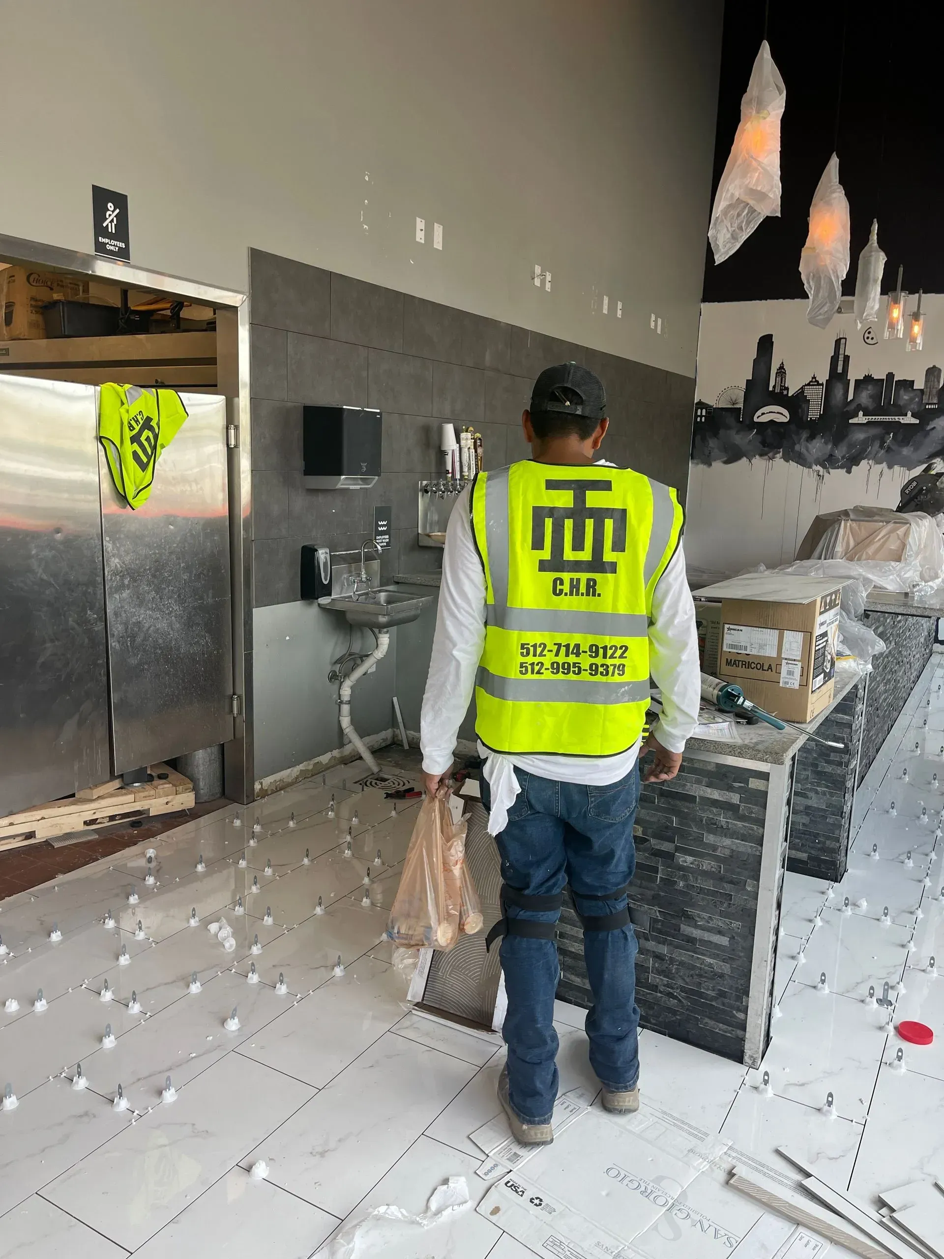 A man wearing a yellow vest is standing in a room.