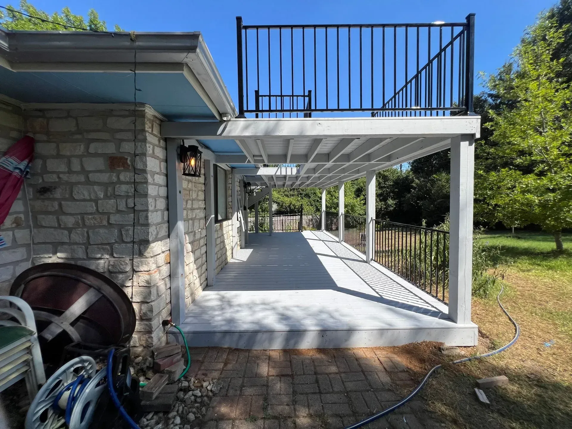 A brick house with a large porch and a black railing