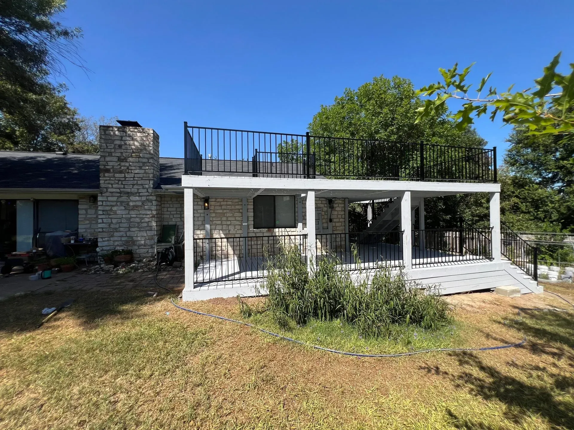 A house with a large porch and a balcony on top of it.