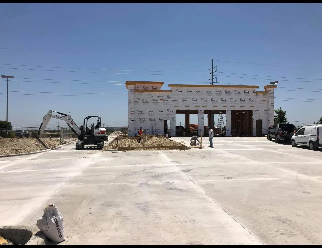 A large building is being built in a parking lot.