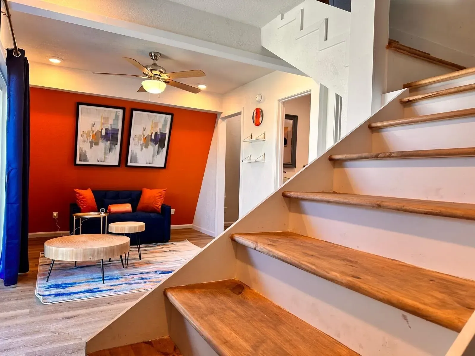 A living room with stairs leading up to the second floor.