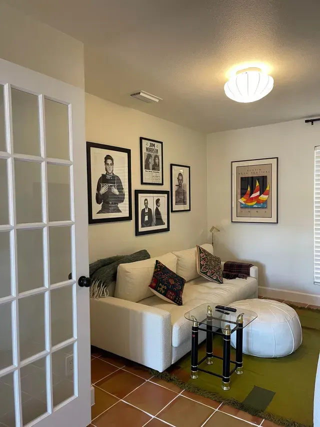 A living room with a white couch and a glass table