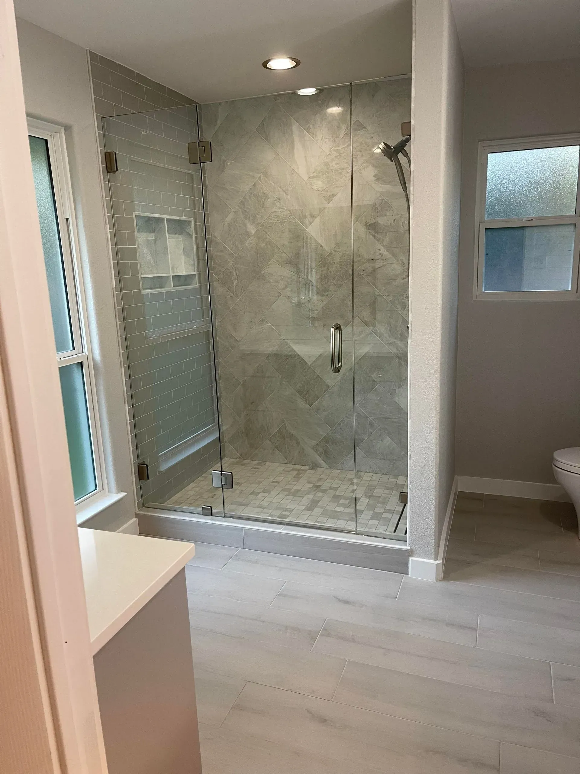 A bathroom with a walk in shower and a toilet.