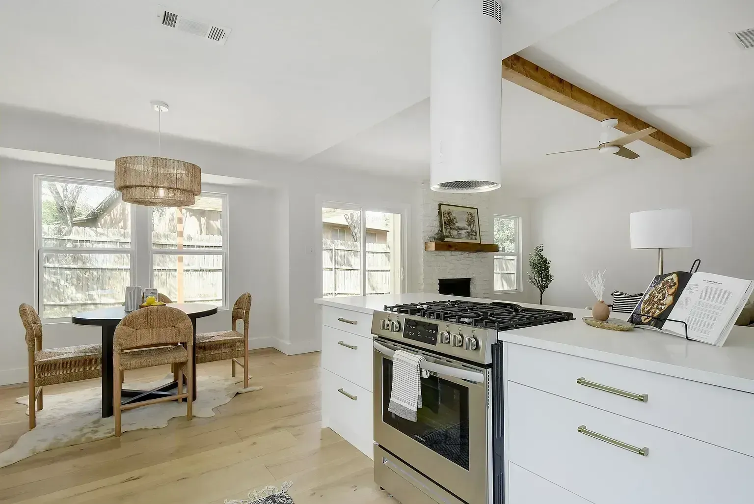 A kitchen with a stove , oven , table and chairs.