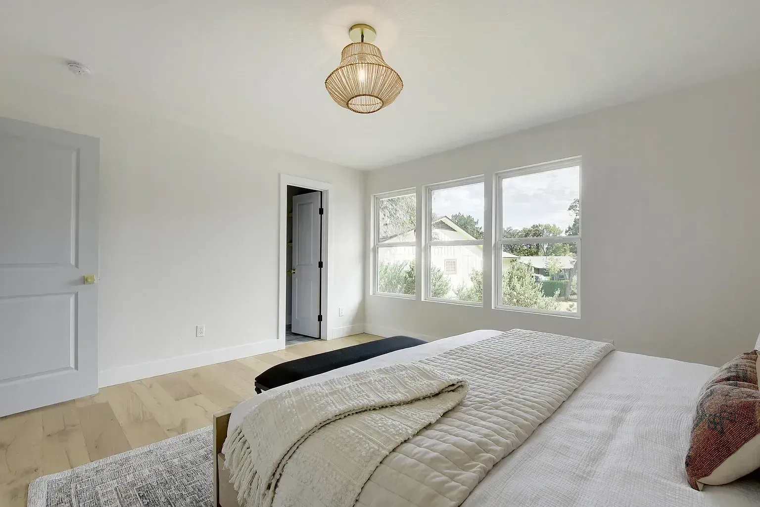 A bedroom with a bed and a chandelier hanging from the ceiling.