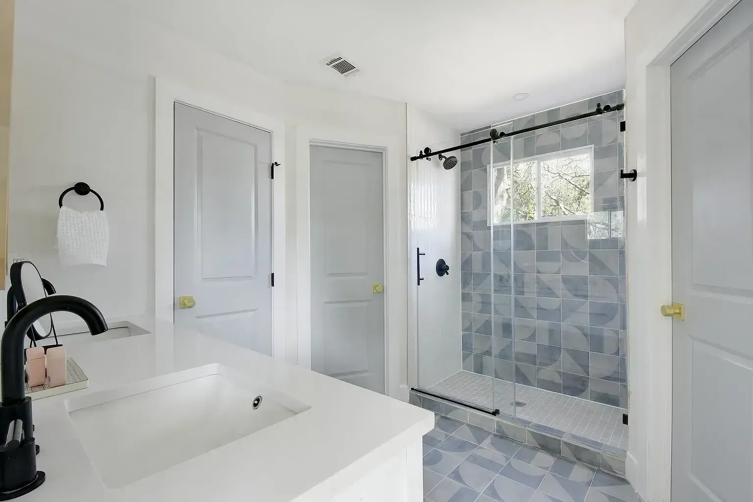 A bathroom with a sink and a walk in shower.