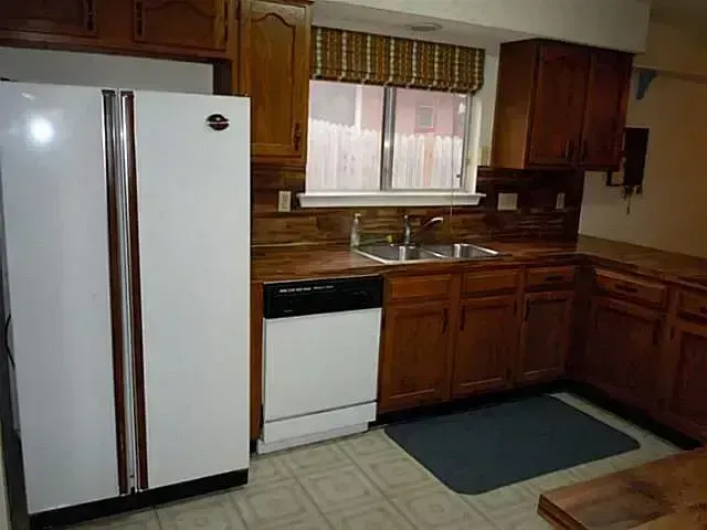 A kitchen with wooden cabinets and a white refrigerator