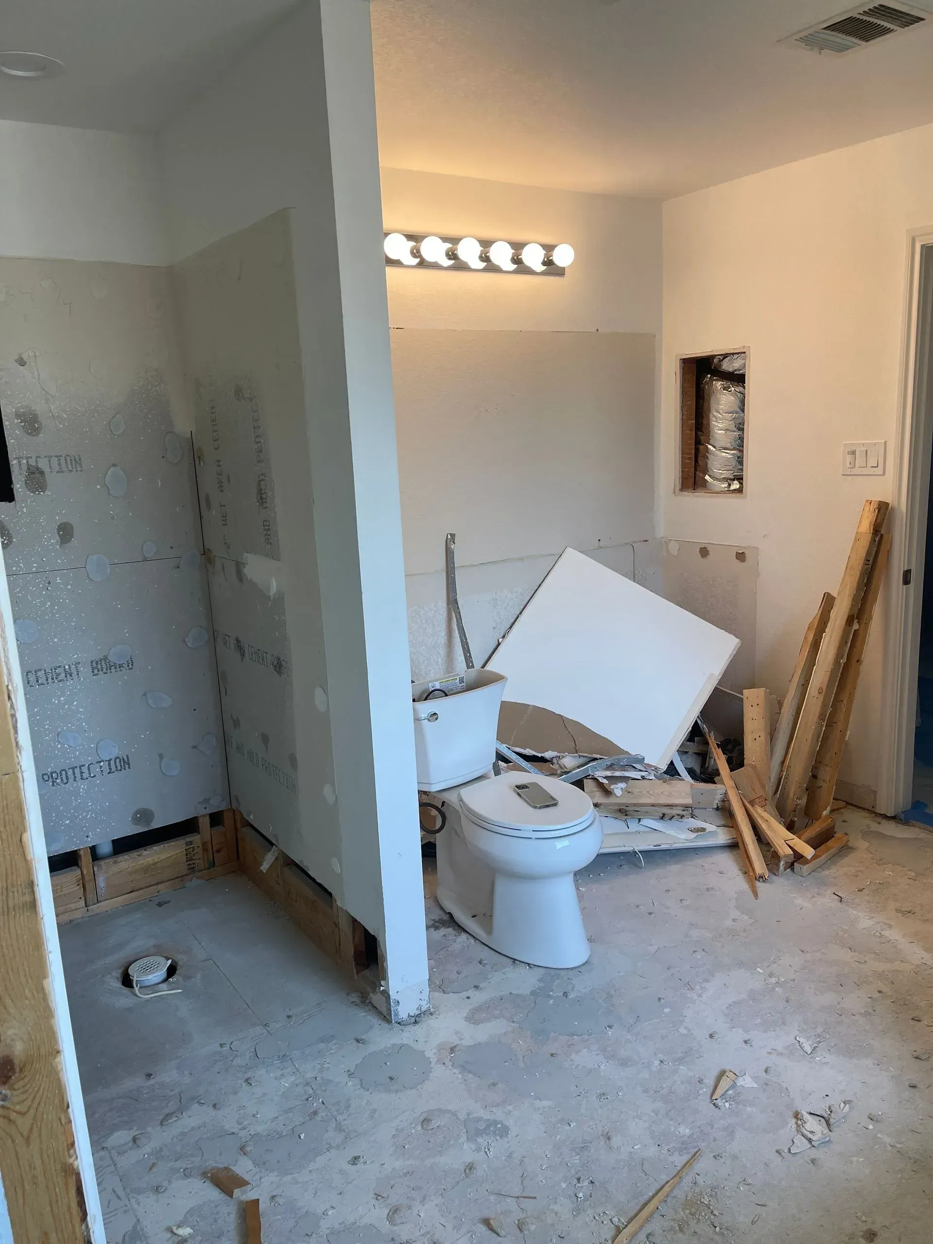 A bathroom under construction with a toilet and shower.