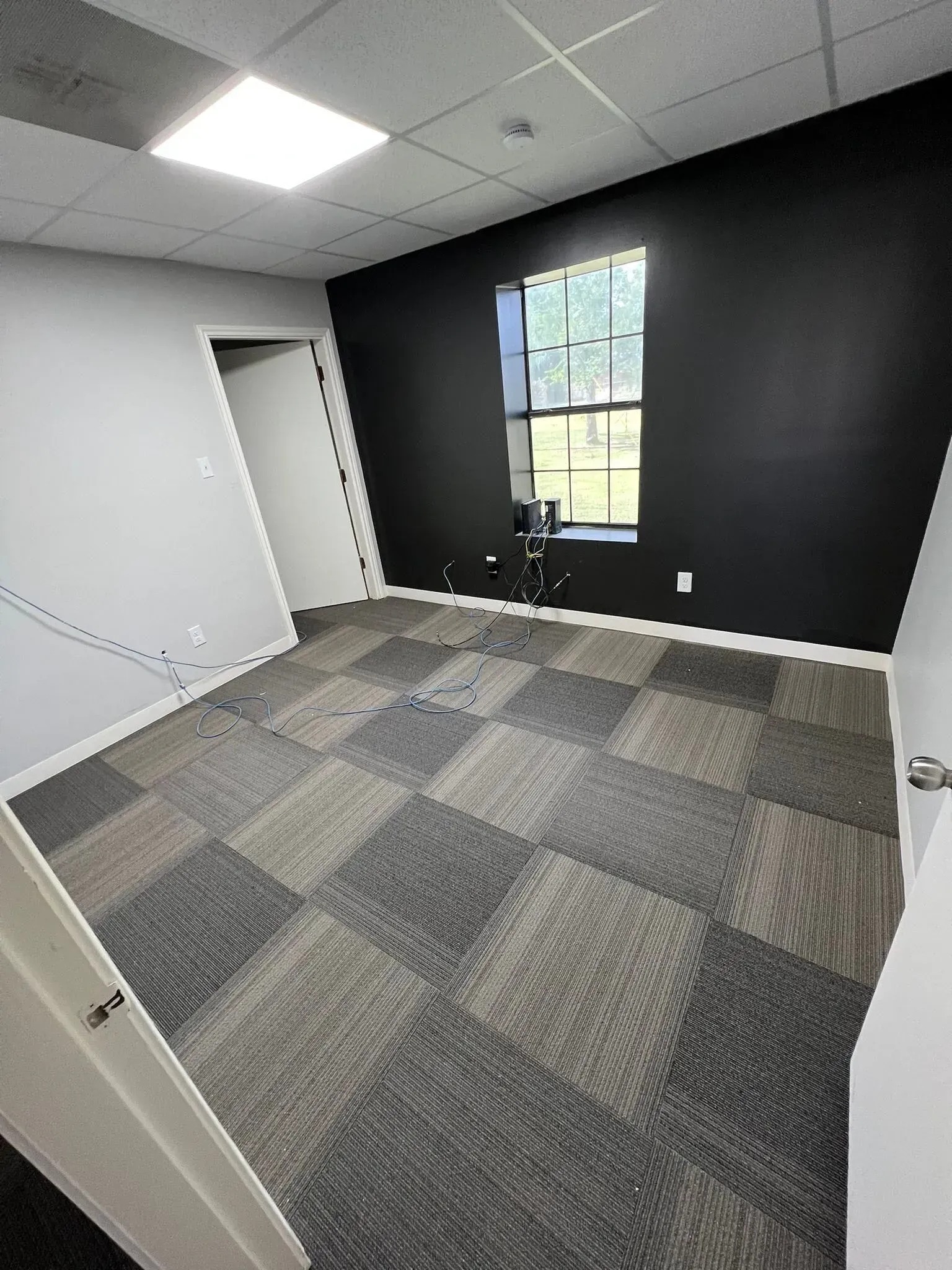 An empty room with a tiled floor and a window.