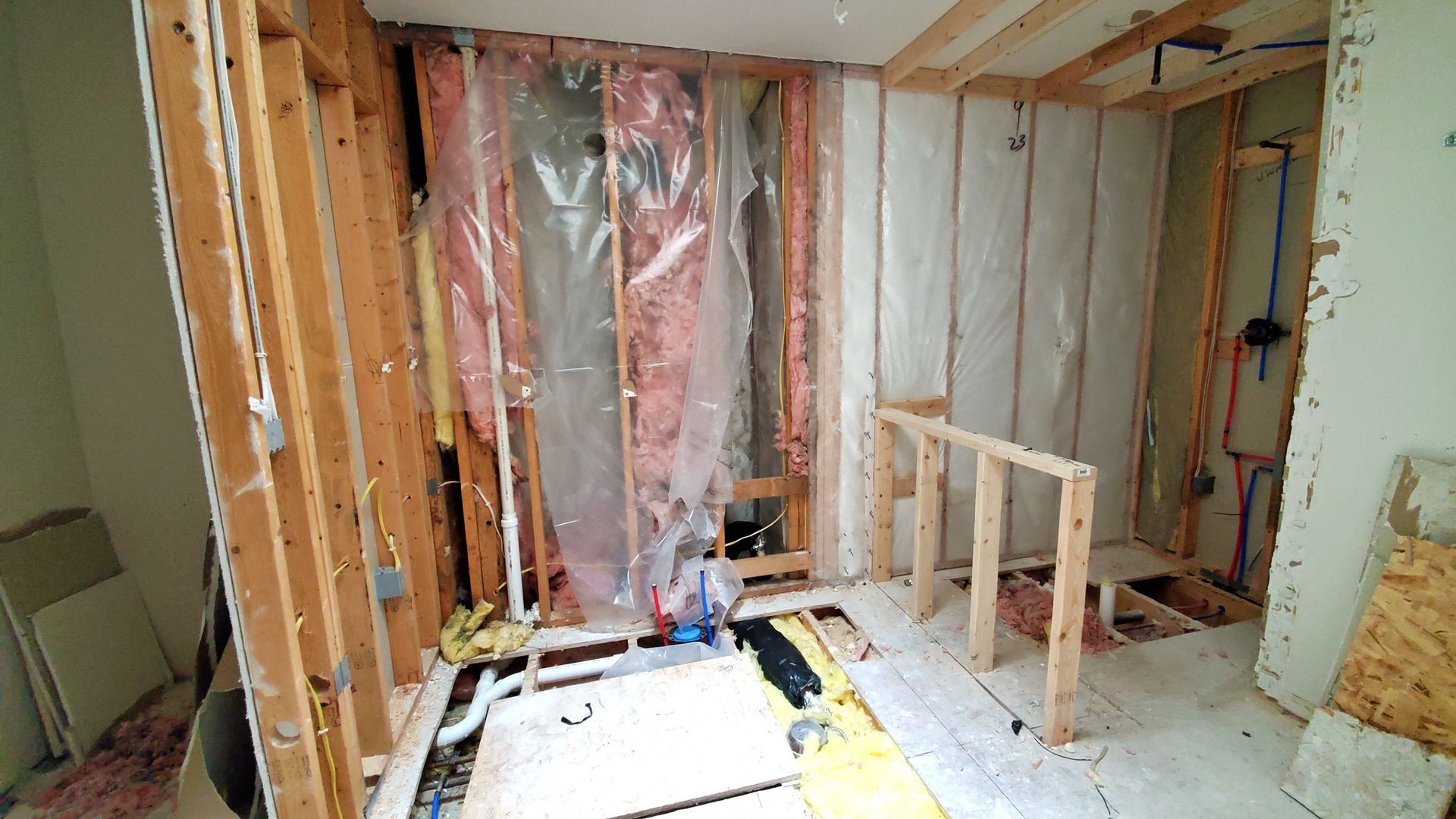 A room that is being remodeled with wooden beams and insulation.