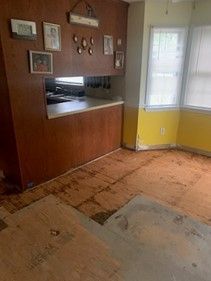 A living room with a wooden floor and a yellow wall.