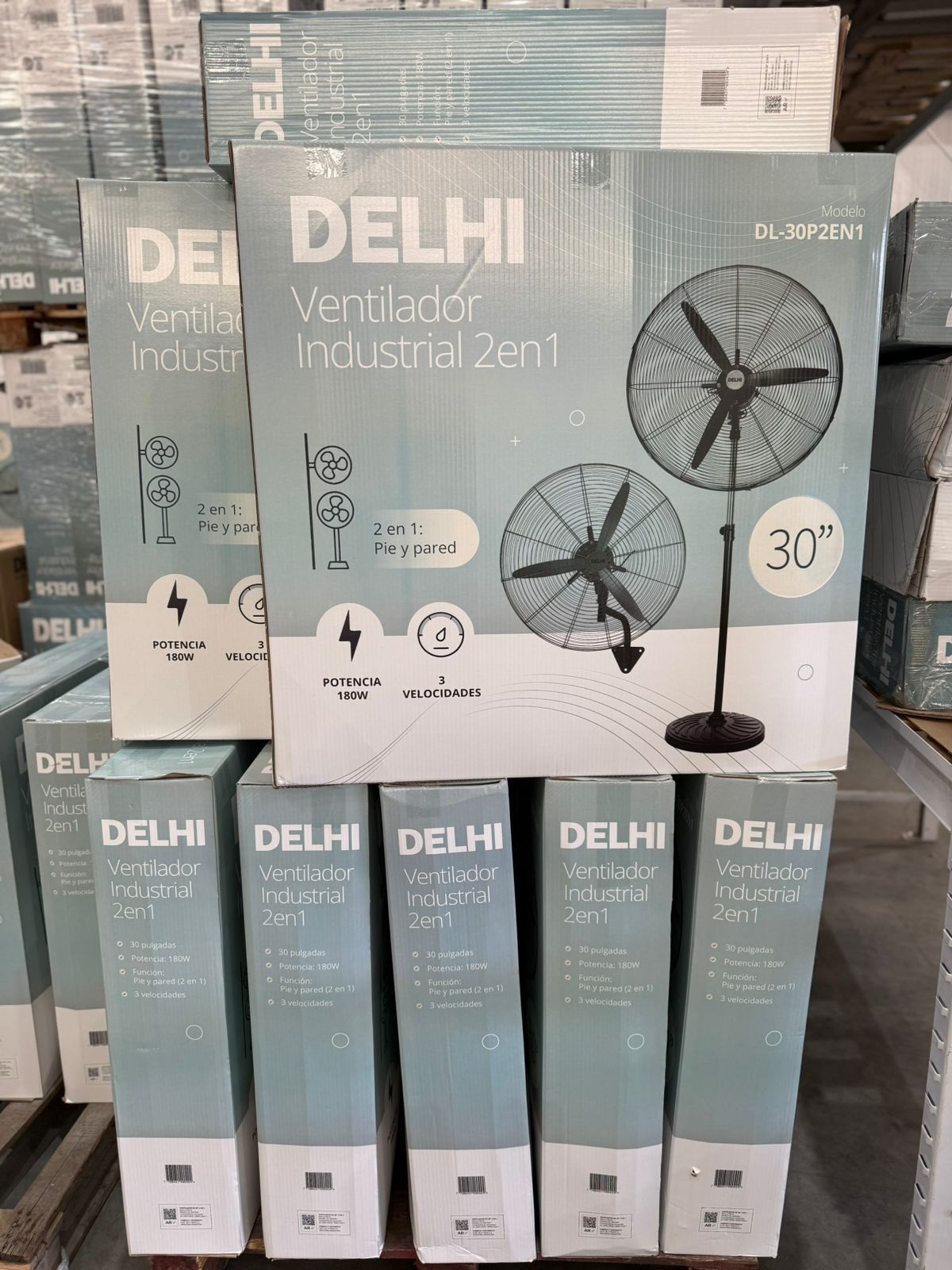 Cajas de ventiladores industriales de Delhi apiladas en un palé; los ventiladores son negros y tienen un diámetro de 30