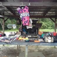 A roadside stand under a wooden shelter features a 