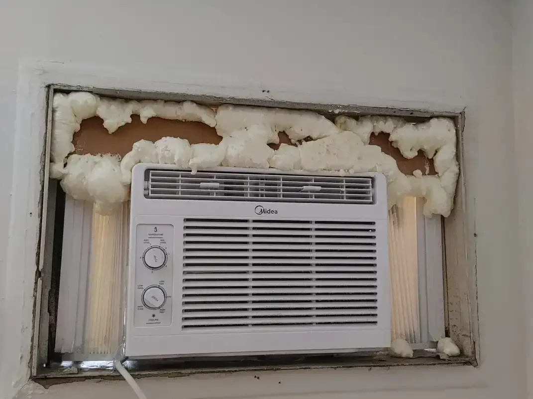 Spray foam insulation improperly applied to a window mount air conditioner that may cause damage.