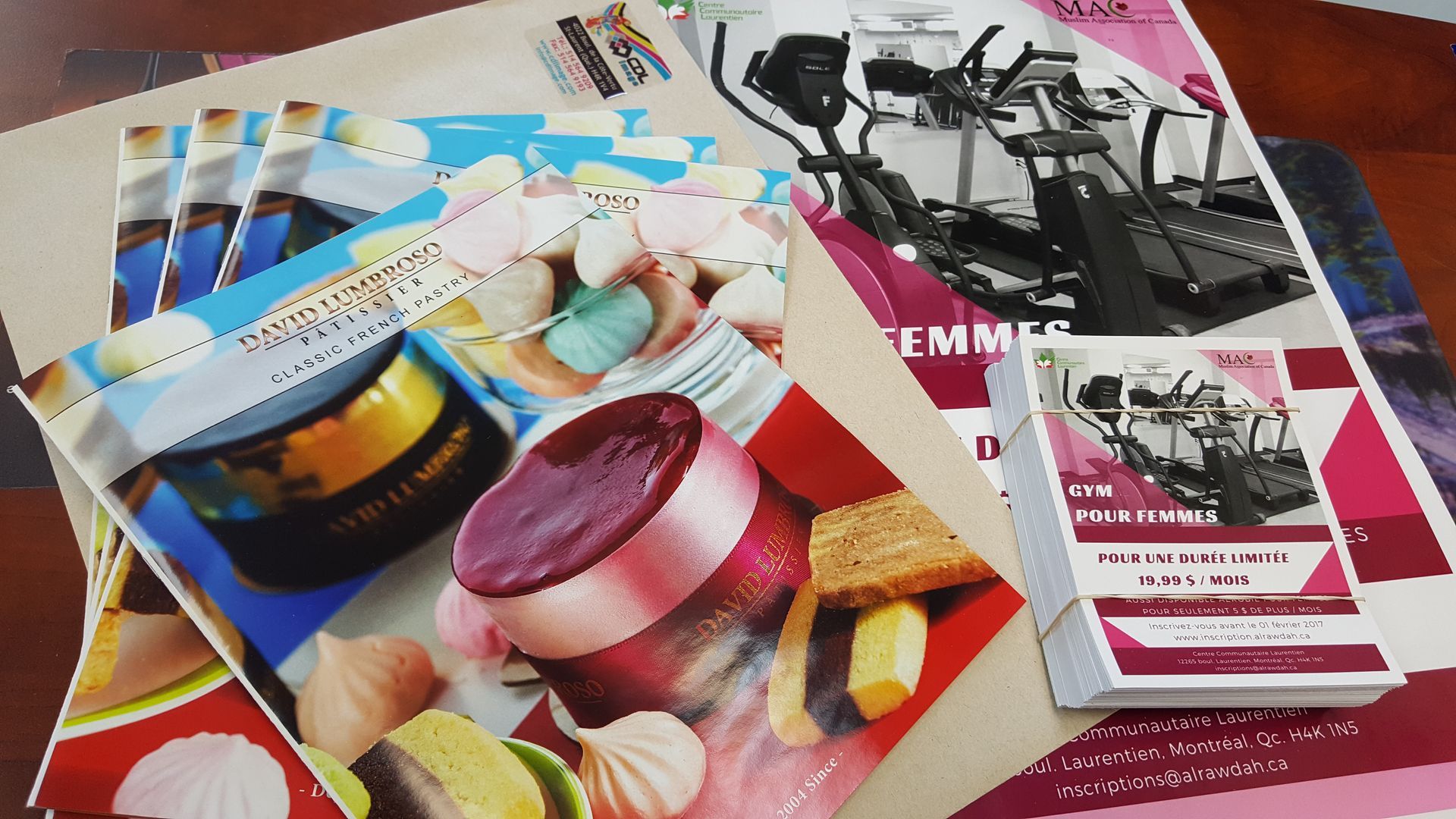 Pile of colorful marketing materials with fitness equipment and desserts.