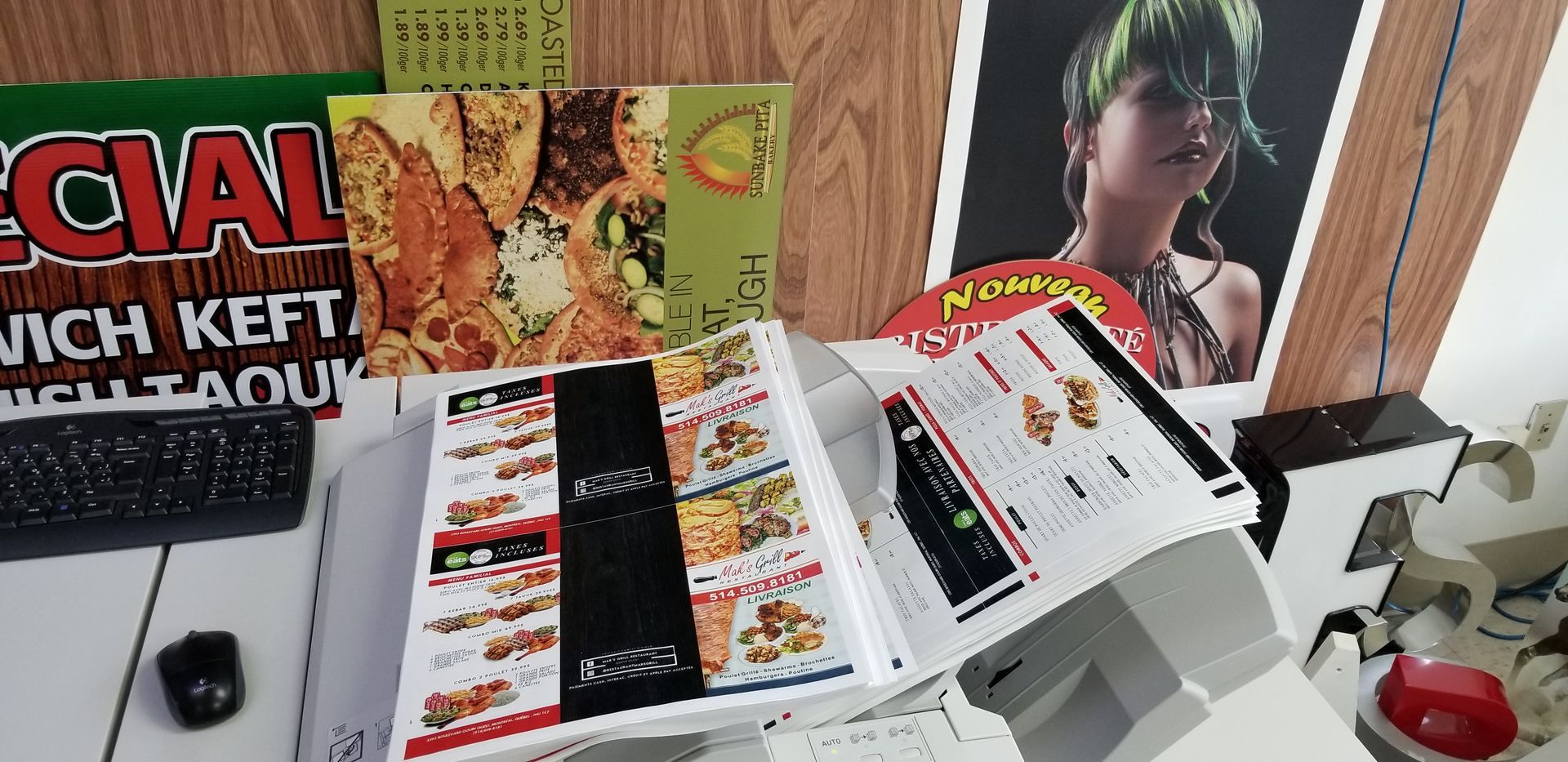 Desk with food flyers, a keyboard, and a poster of a person with green hair.