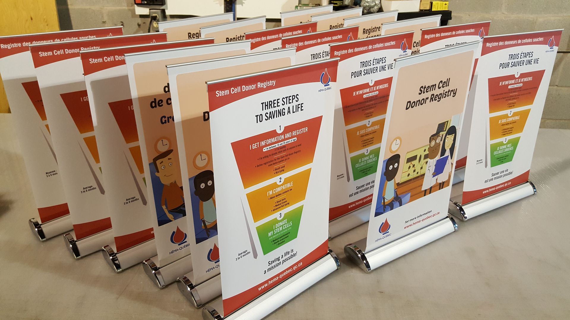 Rangées de bannières promotionnelles enroulables aux designs variés, présentant des infographies colorées et du texte sur une table.