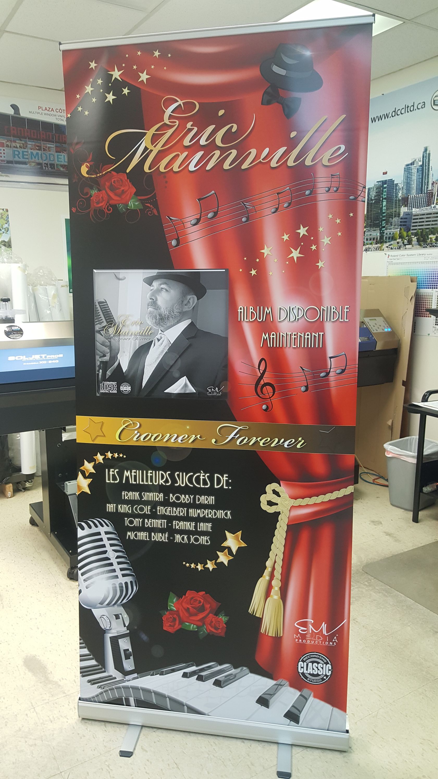 Banderole déroulante : Publicité du spectacle d'Eric Mainville. Rouge et noir, avec photo de l'artiste, micro et détails du spectacle.