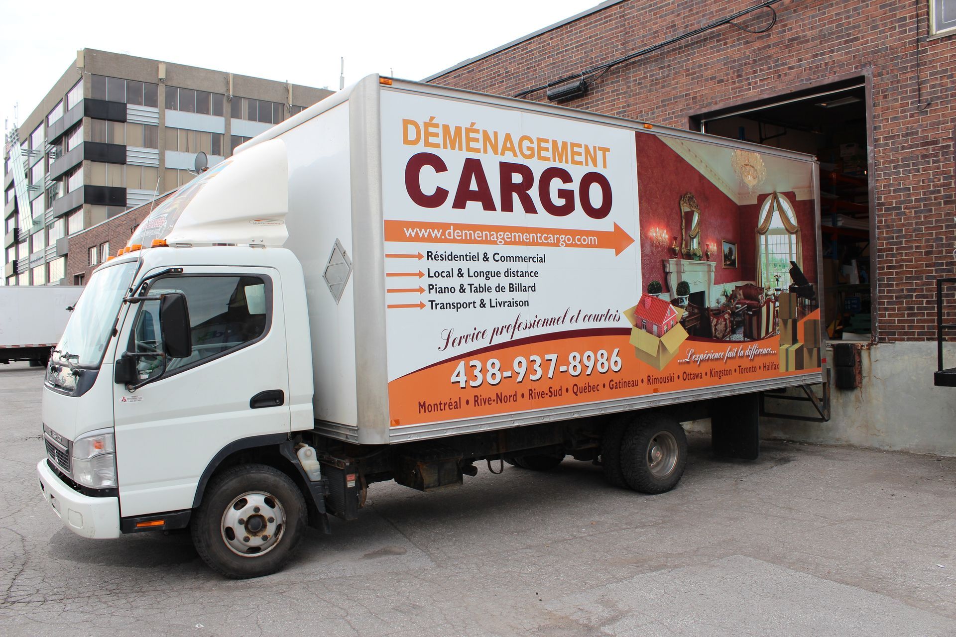 Camion de marque UpCar blanc, stationné, extérieur la nuit.