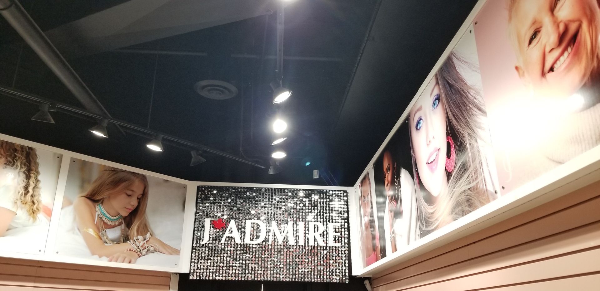 Mur intérieur de la boutique avec de grands portraits et le mot « ADMIRE ».