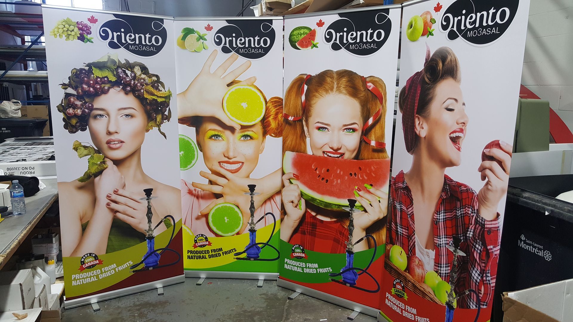 Four colorful banners: women with fruit representing hookah flavors.