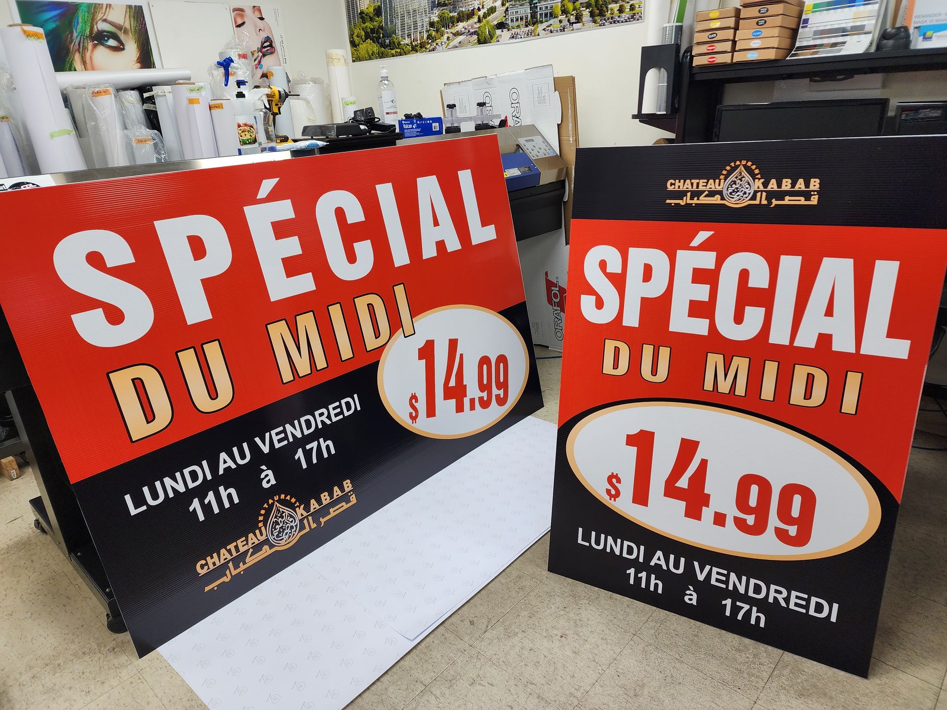 Deux panneaux sandwich rouges et noirs annonçant un « Spécial du Midi » à 14,99 $, du lundi au vendredi, de 11h à 17h.