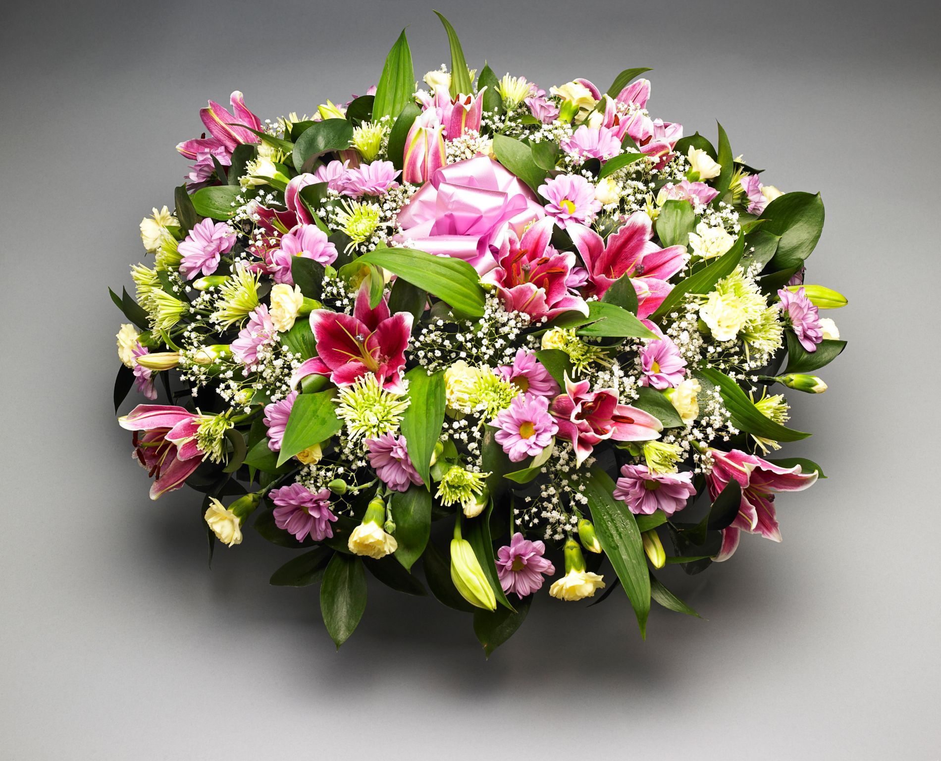 Un mazzo di fiori rosa e gialli su uno sfondo grigio