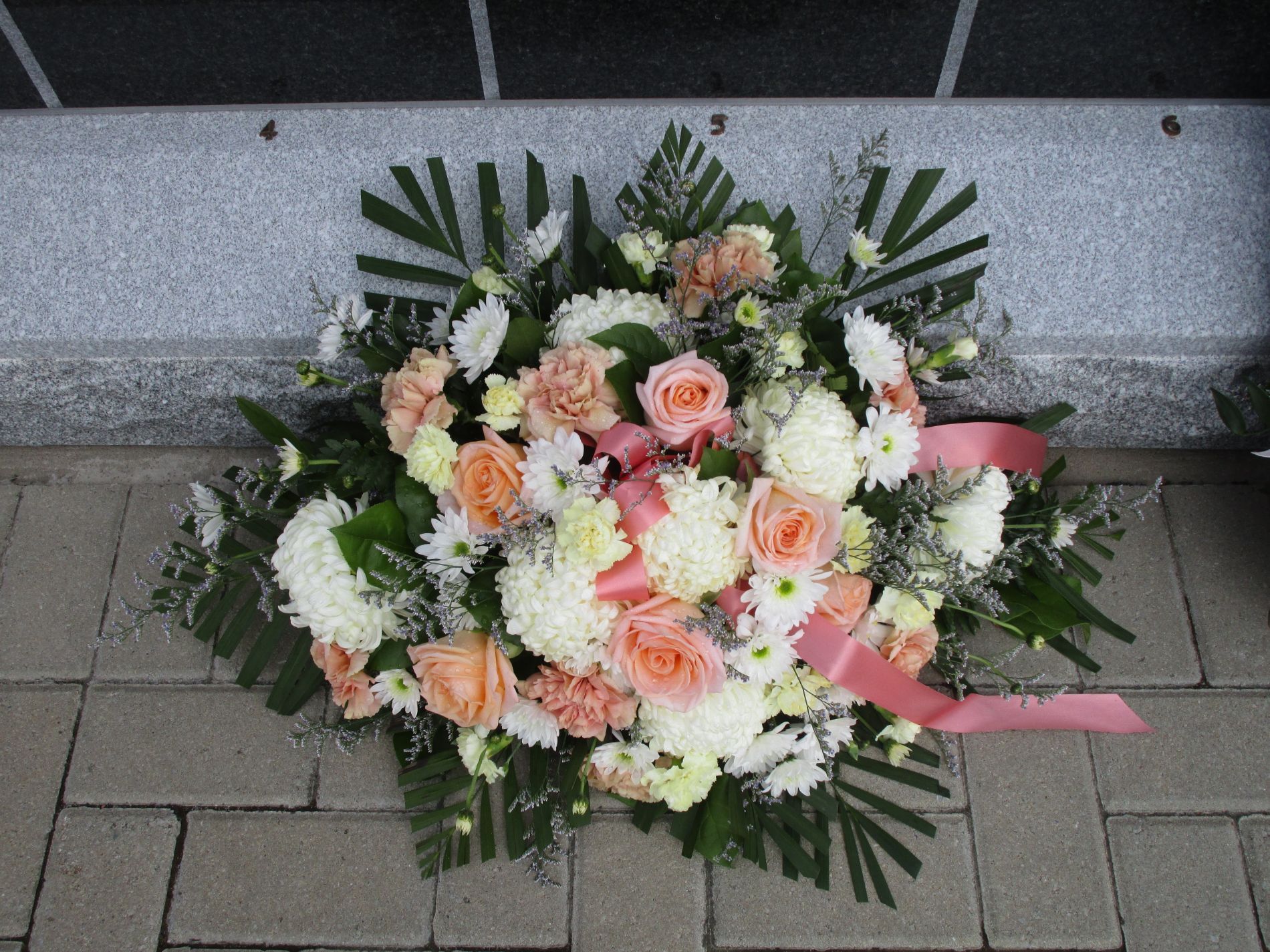 Un mazzo di fiori rosa e bianchi con un nastro rosa