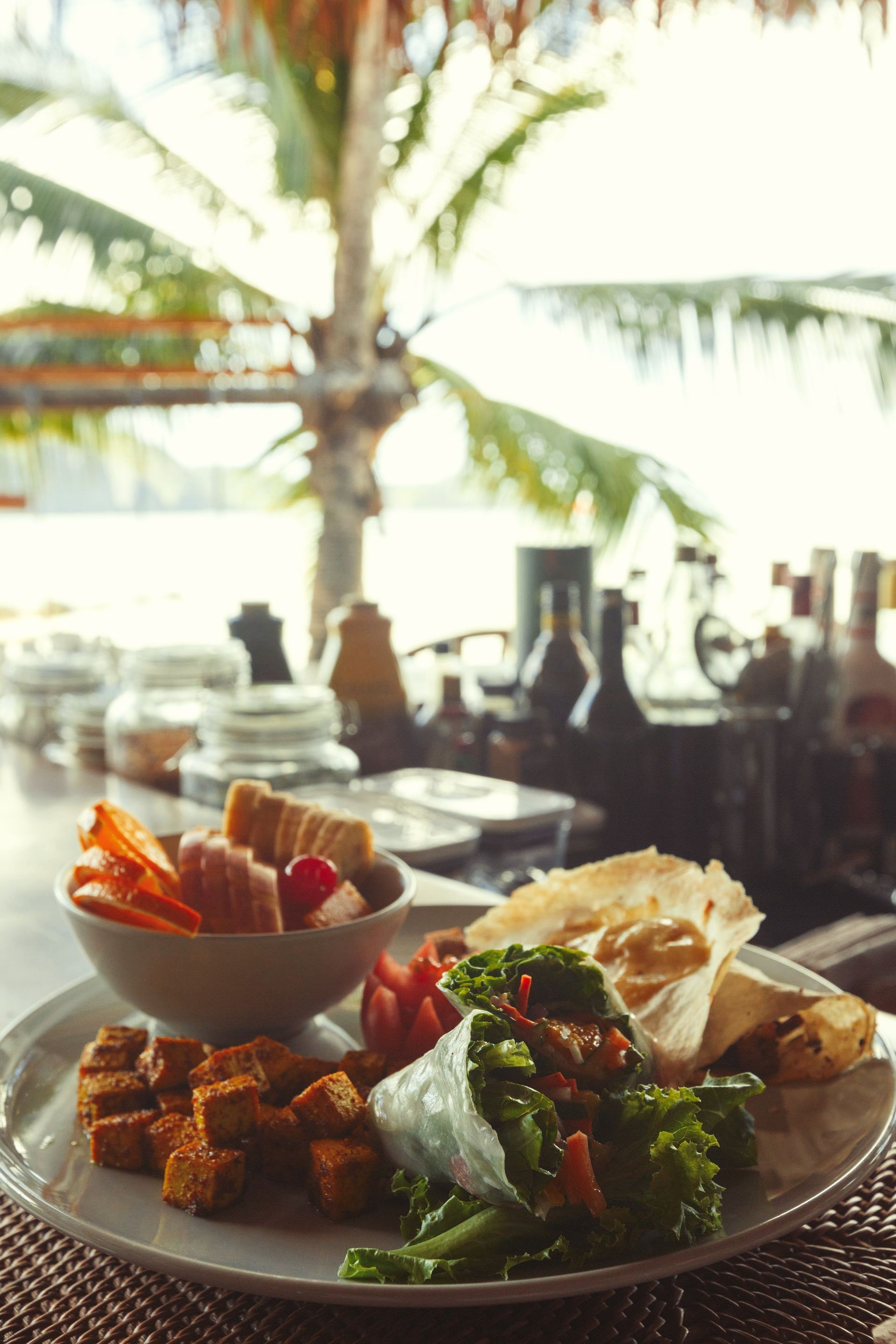 A plate of food is sitting on a table with a palm tree in the background.