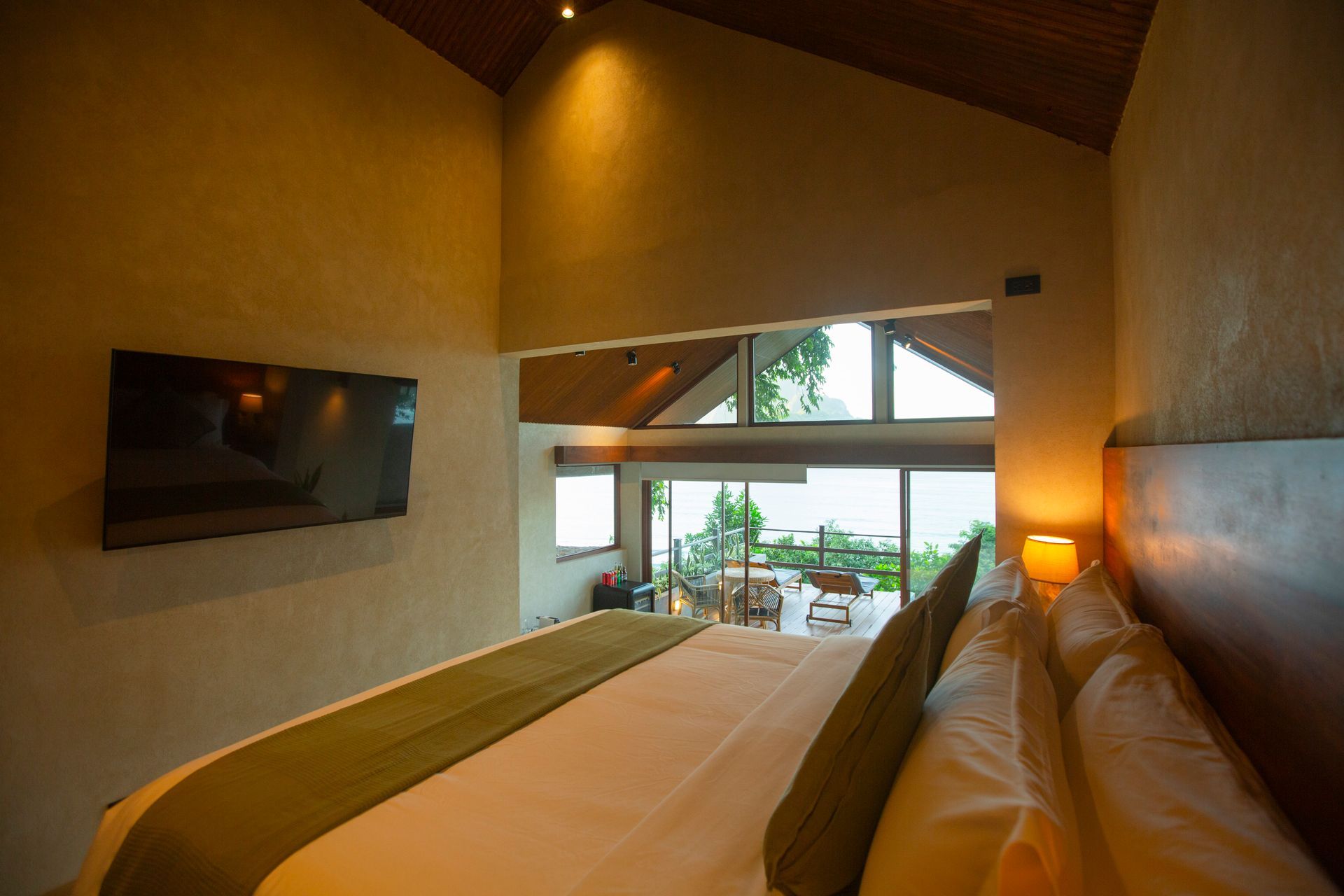 A hotel room with a king size bed and a flat screen tv.