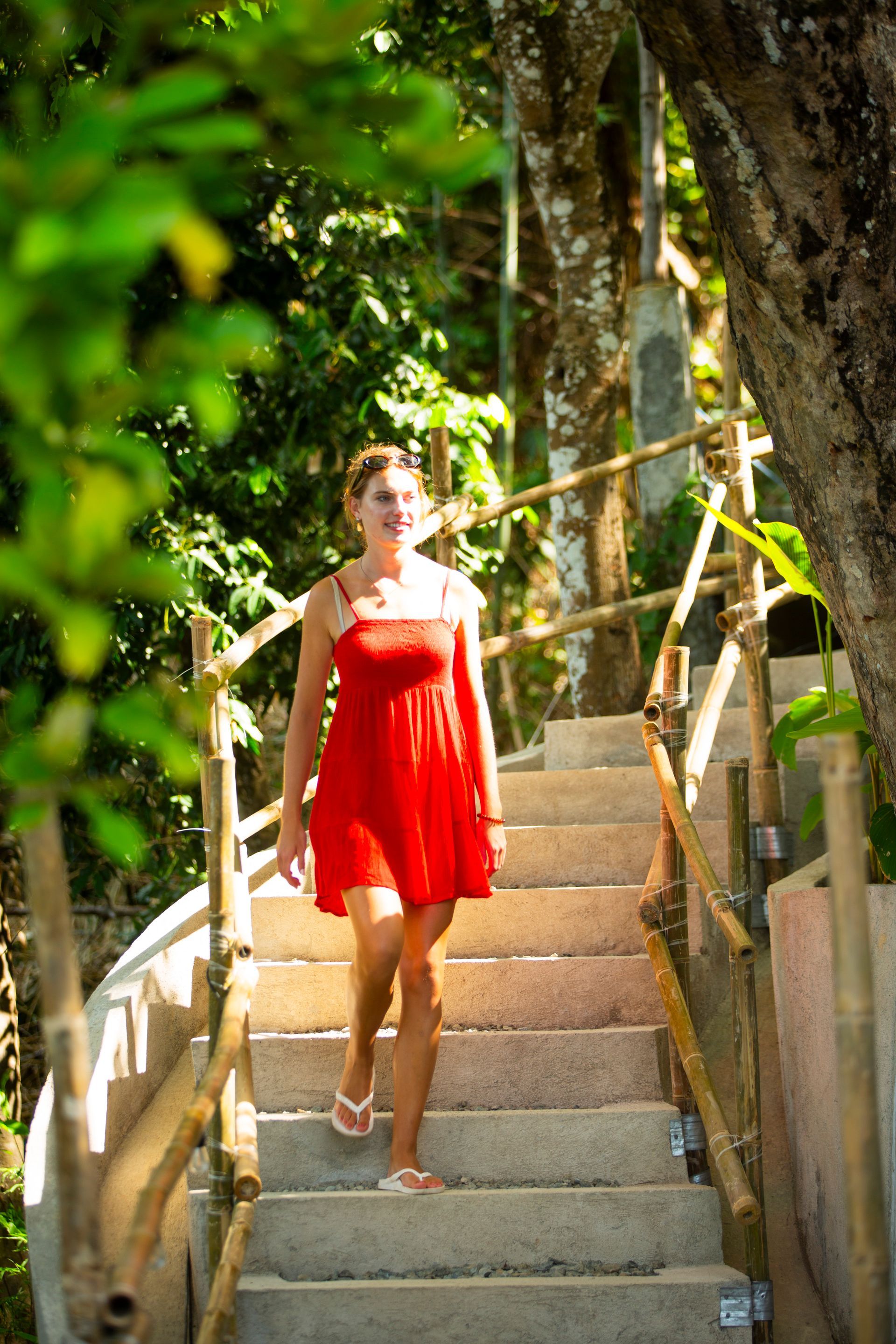 A woman in a red dress is walking up a set of stairs.