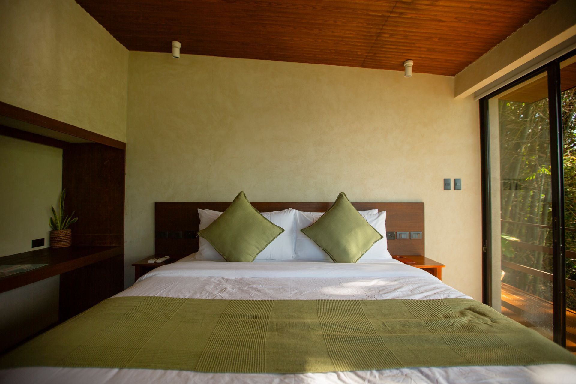 A bedroom with a large bed and a sliding glass door.