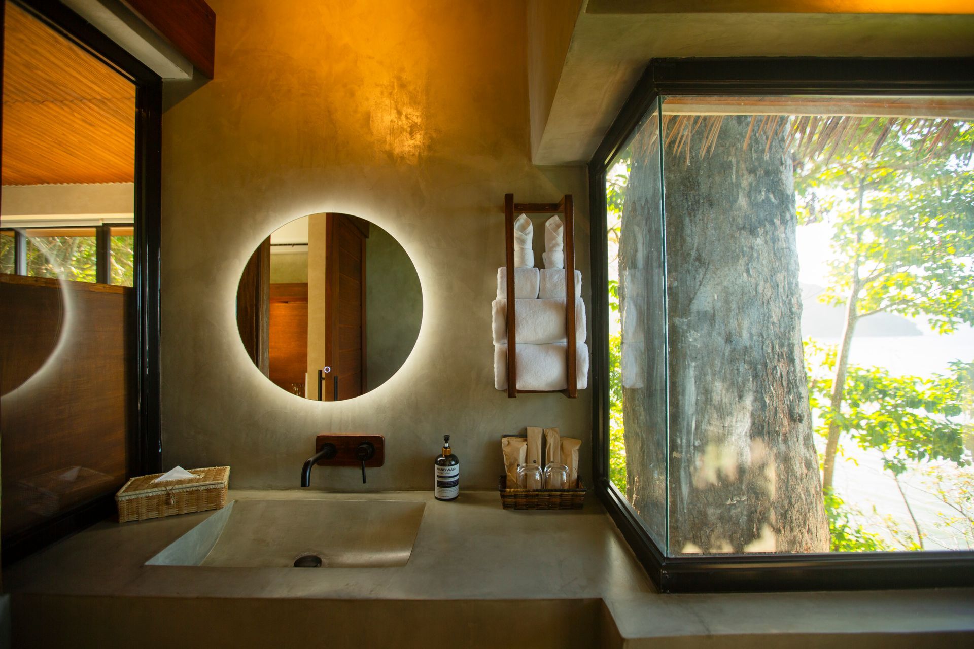 A bathroom with a sink , mirror and window.