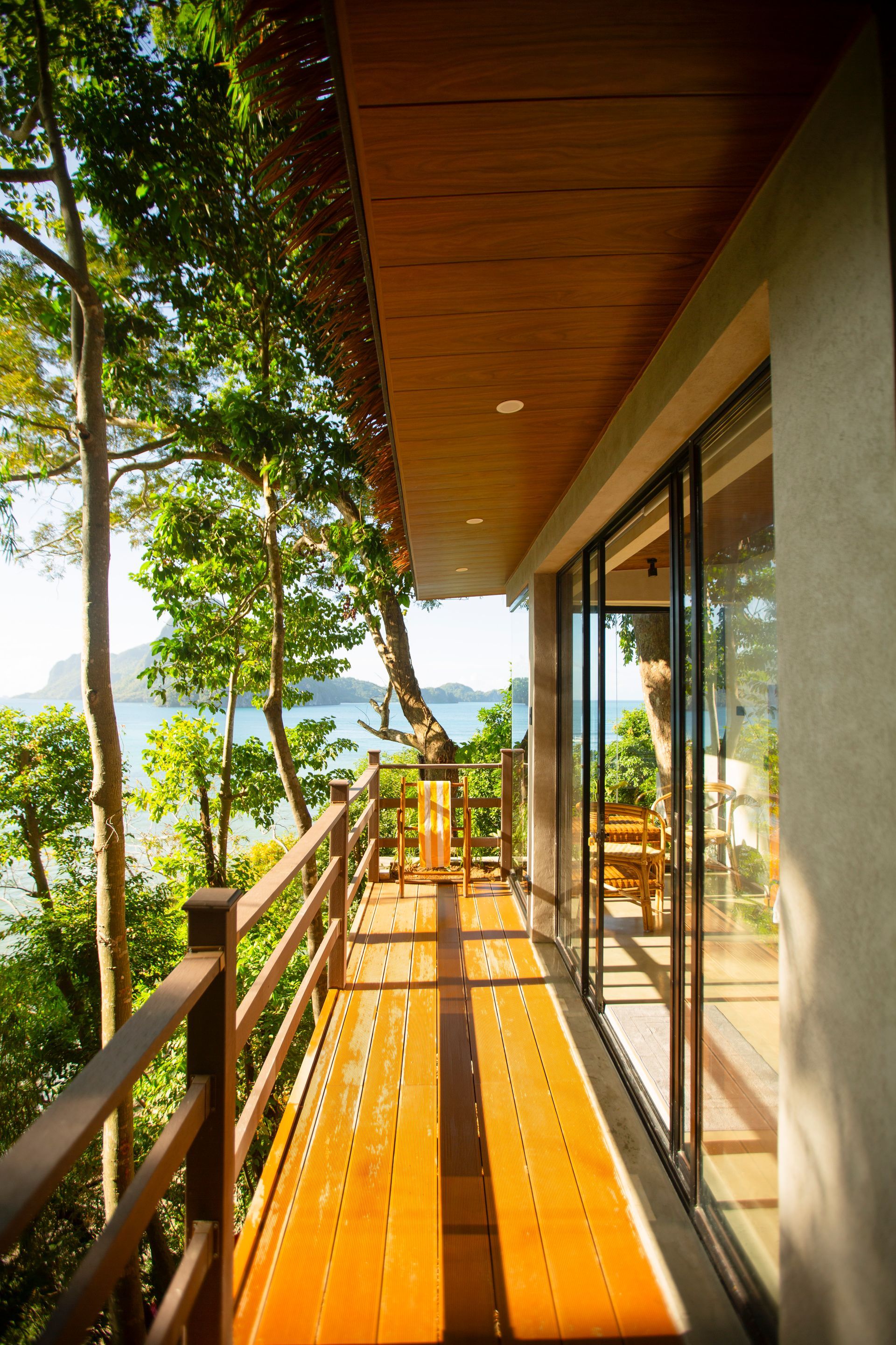 A balcony with a view of the ocean and trees.