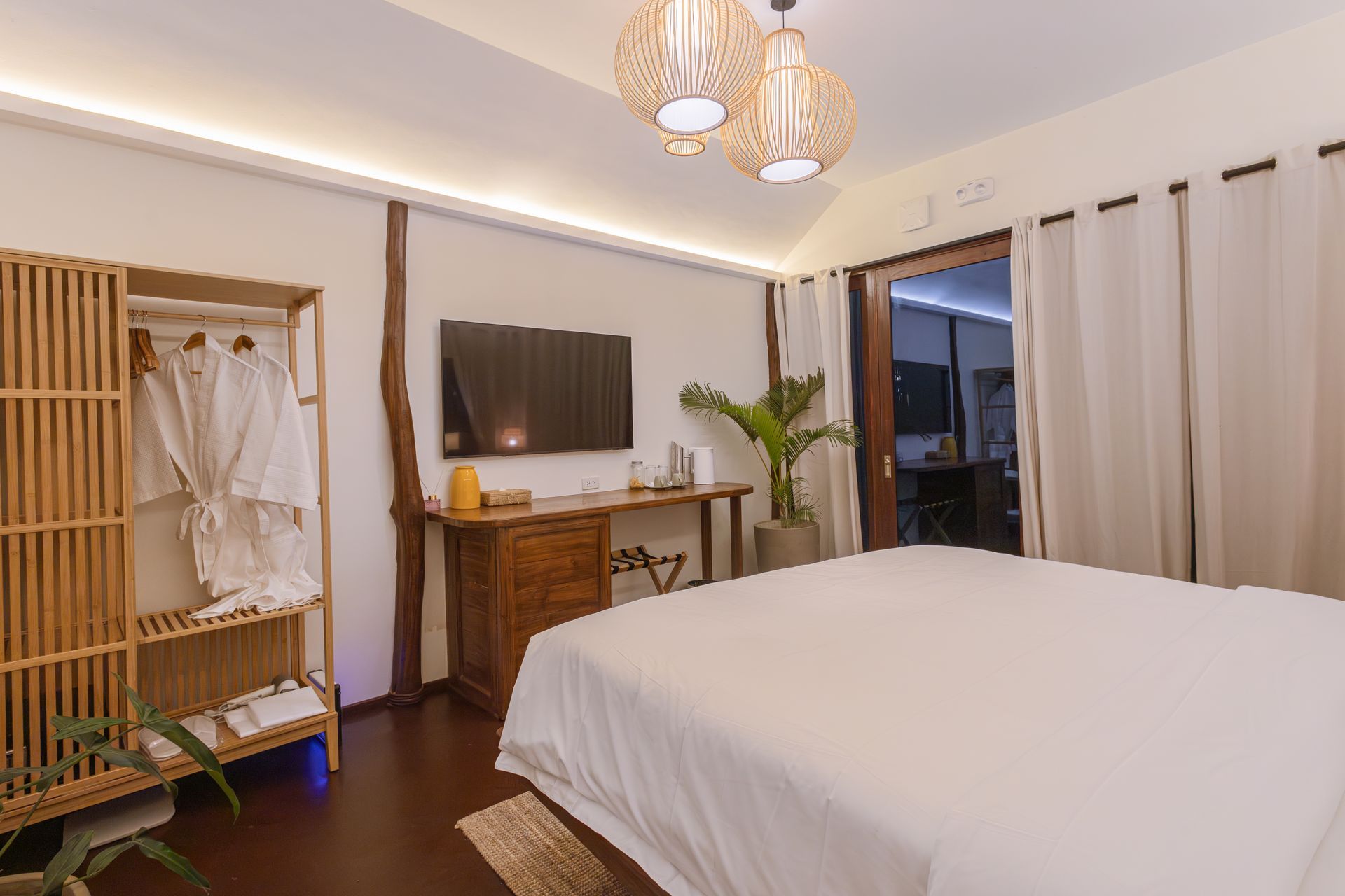 A bedroom with a king size bed , television , desk and closet.