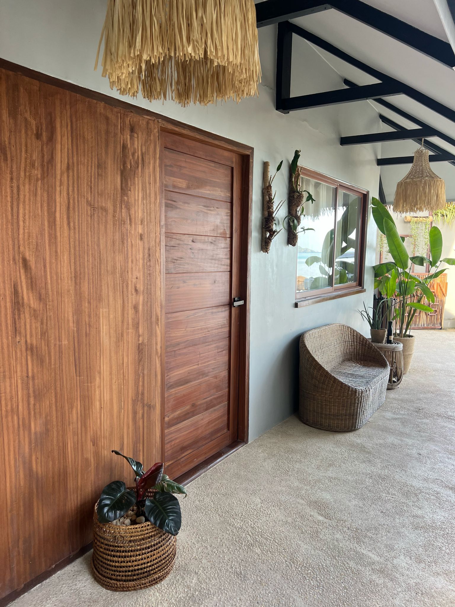 A wooden door with a wicker chair in front of it.
