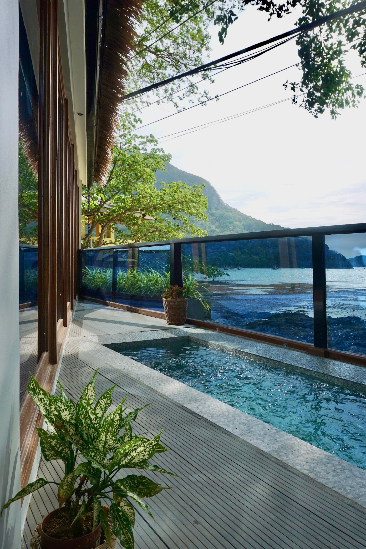 A balcony with a swimming pool and a view of the ocean.