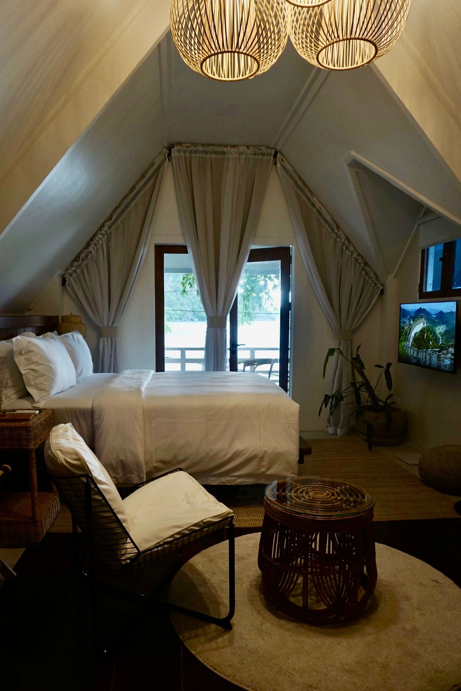 A bedroom with a bed , chair , table and television.