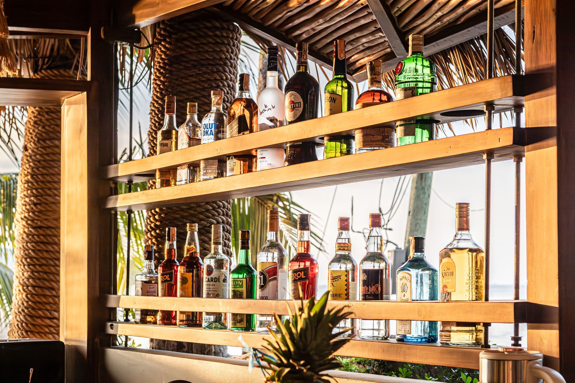 A bar filled with lots of bottles of liquor and a pineapple.